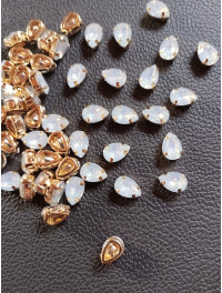 Стразі (акрил) у золотій металевій оправі. Розмір  6*10 мм. Колір білий опал